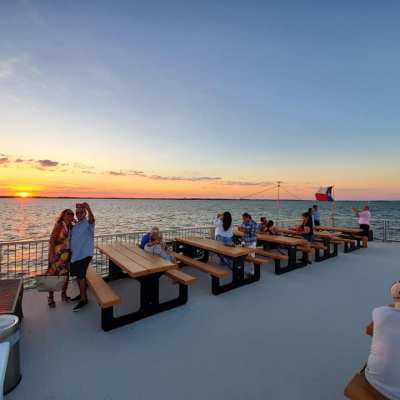 a group of people sitting on a bench next to a body of water